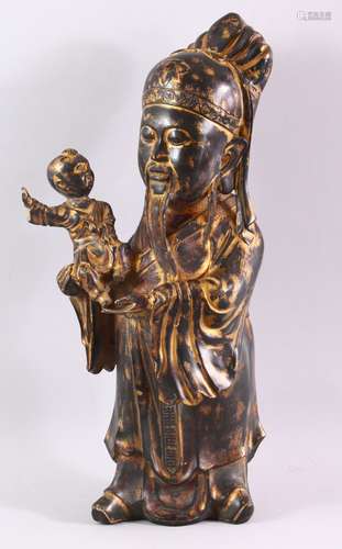 A CHINESE CAST BRONZE FIGURE OF A BEARDED SAGE, holding a small boy in his arms, with traces of