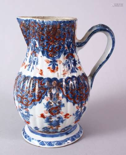 AN 18TH CENTURY CHINESE IMARI RIBBED PORCELAIN JUG, with underglaze blue and orange floral motif