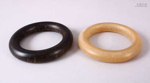 TWO CHINESE HORN STYLE BANGLES, 9cm diameter.