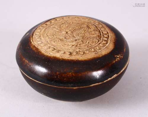 A SMALL CHINESE TREACLE GLAZED CIRCULAR POTTERY BOX AND COVER, the cover with moulded dragon