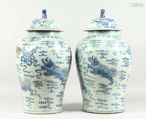 A PAIR OF 20TH CENTURY CHINESE BLUE AND WHITE BALUSTER SHAPE TEMPLE JARS AND COVERS, painted with