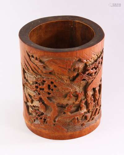 A GOOD CHINESE BAMBOO BRUSH POT, deeply carved with figures in a mountainous landscape, 18cm high.