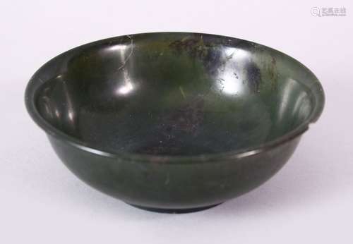 A PLAIN CHINESE CIRCULAR JADE BOWL, with mottled decoration, signed on base, 12cm diameter.