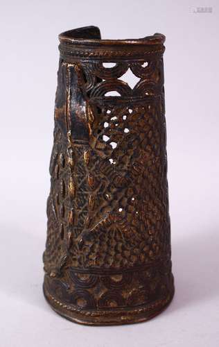 AN UNUSUAL BENIN BRONZE ARM GUARD, relief cast and pierced with a crocodile, 18cm long.