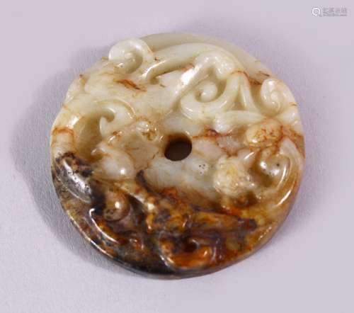 A 19TH CENTURY SPECKLED JADE CIRCULAR ROUNDEL, carved with scrolls, 4.5cm diameter.