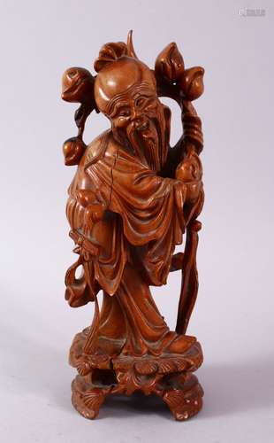 A 19TH CENTURY CARVED WOODEN FIGURE OF SHOU LAO, stood with his head tilted holding his staff and