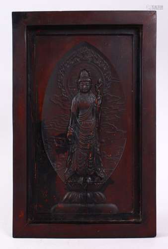 A 19TH CENTURY CHINESE CARVED WOODEN PANEL OF GUANYIN, stood amongst lotus and clouds, framed