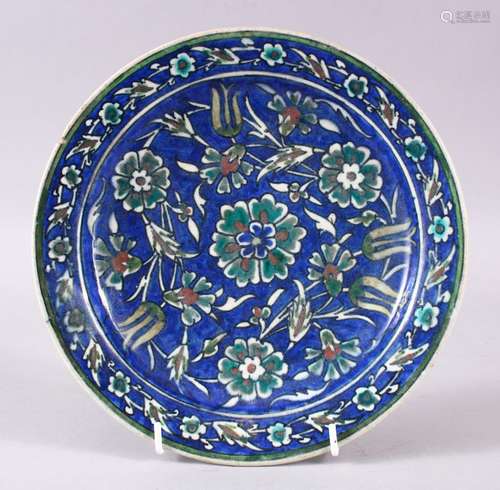 A 19TH/20TH CENTURY PAINTED POTTERY DISH, in the Iznik style, 23cm diameter.