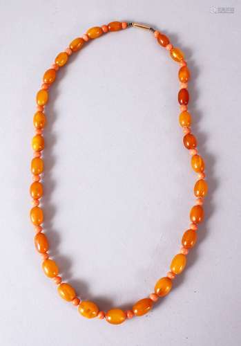 A CHINESE CARVED AMBER AND CORAL BEAD NECKLACE, with graduated oval beads and open measuring 47cm.