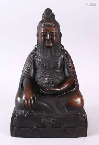 A CHINESE BRONZE CAST FIGURE OF DEITY OR BUDDHA, in a seated position holding a vessel in