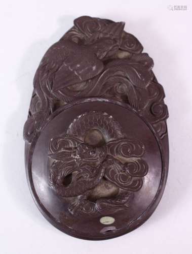 A 19TH/20TH CENTURY INKSTONE AND CIRCULAR COVER, carved with dragons and birds, 16cm x 11cm.