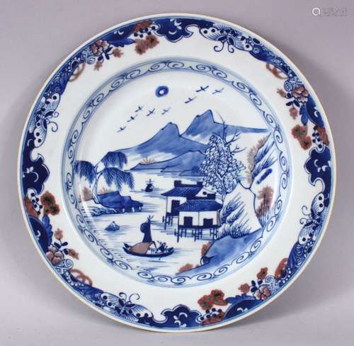 A CHINESE BLUE, WHITE & IRON RED PORCELAIN PLATE, decorated with native waterside landscape views