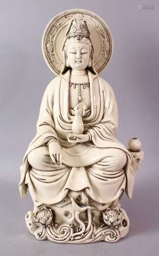 A LARGE CHINESE DEHUA / BLANC DE CHINE PORCELAIN FIGURE OF GUANYIN, in a seated pose upon a rocky