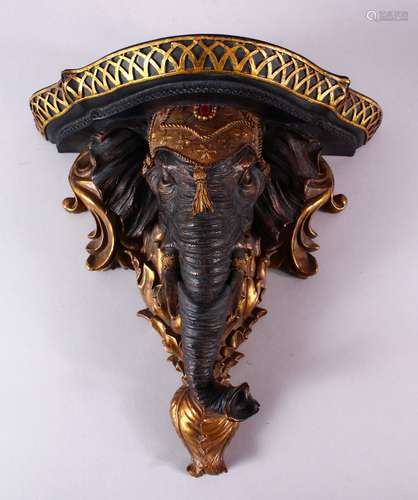 A NICELY CARVED INDIAN ELEPHANT FORMED WALL BRACKET, carved with an elephant head amongst gilded