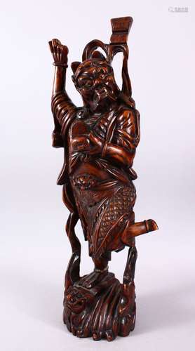 A LARGE 19TH CENTURY CHINESE CARVED HARDWOOD FIGURE OF A DEVIL, stood upon a wave formed base with