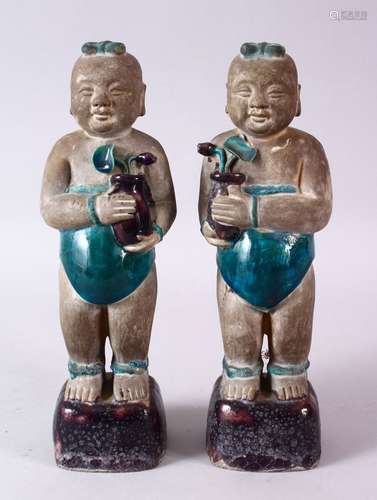 A PAIR OF 19TH CENTURY OR EARLIER CHINESE TURQUOISE AND AUBERGINE GLAZED POTTERY FIGURES OF BOYS,