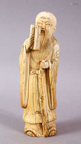 A 17TH / 18TH CENTURY CHINESE CARVED IVORY FIGURE OF A SCHOLAR, stood holding a scroll and his