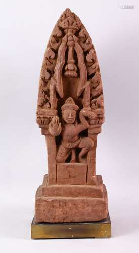 A CAMBODIAN KHMER STYLE CARVING OF A CROUCHING FIGURE IN A TEMPLE.