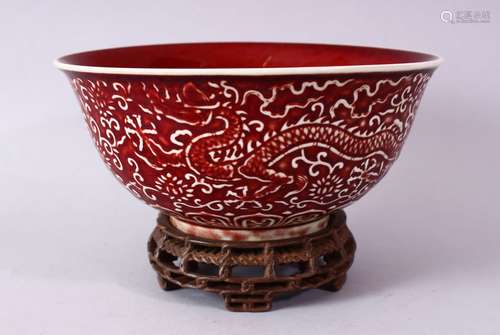 A CHINESE COPPER RED CARVED COPPER RED PORCELAIN DRAGON BOWL, with decoration of dragins amongst