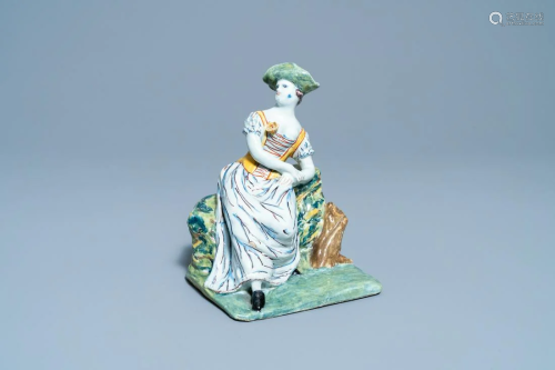 A polychrome Dutch Delft figure of a seated lady, 18th