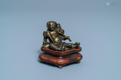 A Chinese bronze 'Liu Hai' scroll weight on wooden