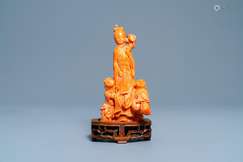A Chinese carved red coral group of a lady with two