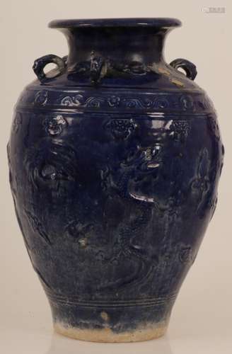 An earthenware blue glazed storage jar with dragon decoration. China, 20th century.