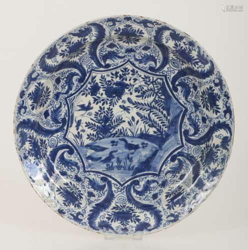 A floral earthenware dish with in the centre a decor of ducks and birds in a landscape. Delft 18th c