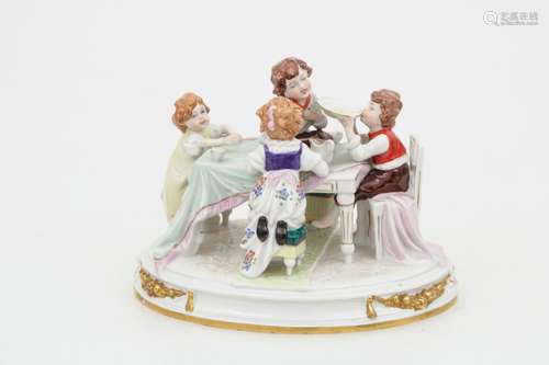 A porcelain group of a group of children at a dining table. Dresden, 20th century.