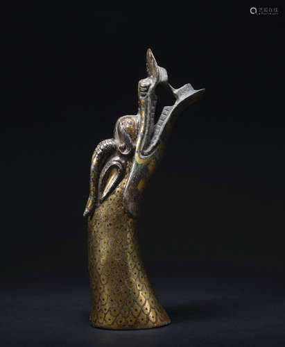 A bronze beast head ware with gold and silver