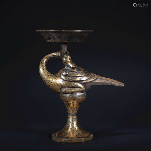 A bronze candlestick ware with gold and silver