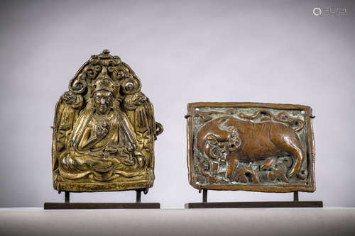 Two Tibetan elements in copper repoussé 'guru rinpoche' (9.5x7 cm) and 'tiger' (6.5x8.5 cm)