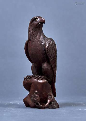 A JAPANESE CARVED AND STAINED WOOD SCULPTURE OF A HAWK, 19TH/20TH C, PERCHED ON A ROCK WITH