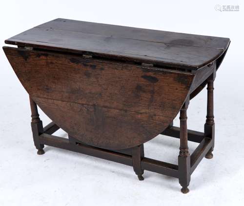 AN OAK GATELEG DINING TABLE, C1680, THE OVAL PLANK TOP ABOVE TURNED BARREL LEGS JOINED BY MOULDED
