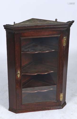A GEORGE III OAK HANGING CORNER CUPBOARD, C1770, THE FLARED CORNICE WITH DENTIL MOULDING ABOVE A