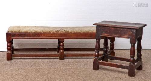 A JOINED OAK LONG STOOL, 17TH STYLE WITH MOULDED RAIL, ON SIX BOBBIN TURNED LEGS AND BLOCK FEET,