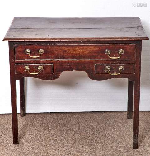 A GEORGE III OAK LOWBOY, C1800, THE OVERSAILING BOARDED TOP WITH MOULDED LIP, FITTED THREE DRAWERS