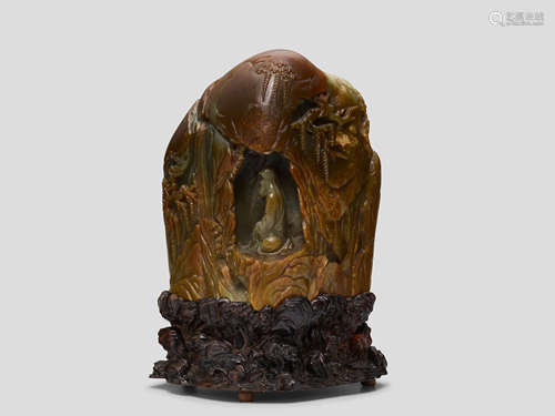 A fine Large russet and green Jade 'Luohan in a grotto' boulder 18th Century