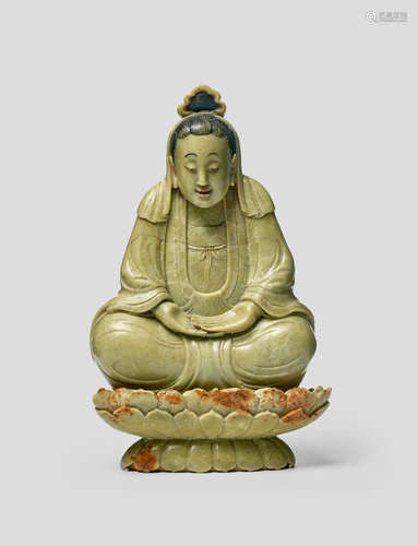 A rare olive-green soapstone figure of a Guanyin on a lotus base Qing dynasty, probably 17th Century