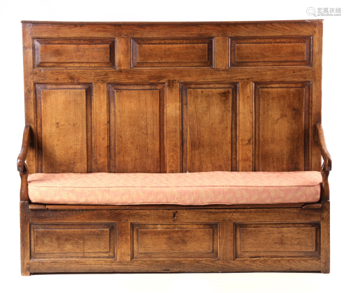 AN EARLY 18TH CENTURY PANELLED OAK BOX SETTLE with high