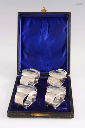 A SET OF FOUR ENGRAVED SILVER NAPKIN RINGS of shaped