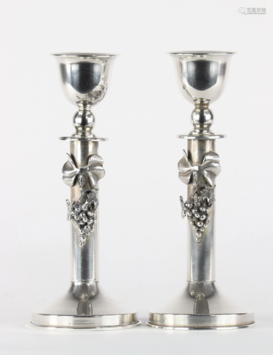 Pair of silver candlesticks decorated with bunches of