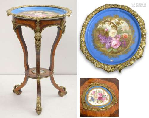 拿破仑三世圆形三足鼎立桌，紫檀木饰面，紫檀木和卷曲镶边，配有带花纹装饰的塞夫勒聚铬瓷搁板以及隔板。鎏金铜饰。大约在1880年。高度：+/-84.5厘米。直径：+/-60cm。