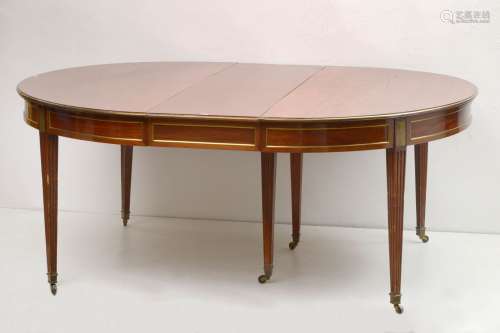 一张重要的路易十六时期的椭圆形桌子，带有桃花心木的延伸部分，黄铜装饰，六条锥形腿，最后是脚轮。时代：18世纪。(裂缝和腿部添加)。Dim.(sans allonge):+/-152x73x139cm.尺寸（含加长）：+/-152x73x454cm。