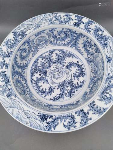 中国，18-19世纪。圆形盘，宽平唇。花卉和风格化枝条的装饰。白釉蓝瓷。高度：10.5厘米，直径：32.7厘米。