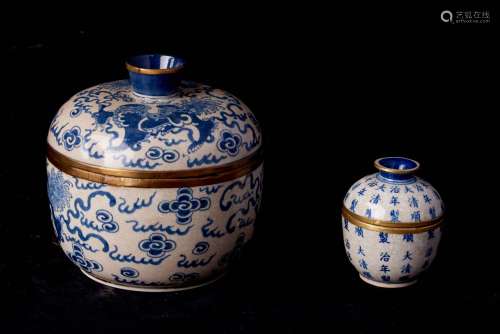 中国，20世纪。裂纹底蓝白釉瓷盖罐两件，其中一件有顺治的凋印。边缘有镀金金属环。(尺寸待定)