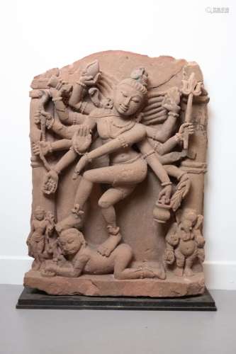 印度，12世纪。大型石碑描绘了湿婆纳塔拉贾用十二条手臂，表演宇宙舞蹈nadânta：站立时，抬起的左腿与右腿交叉，将无知的侏儒压倒在地，从而象征着神灵的知识和智慧。粉砂岩。破胶、震荡和缺乏。高。75厘米，宽度：53厘米。