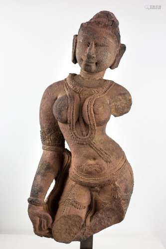 印度，11-12世纪，Khajuraho。高浮雕表现了一个站立的阿普萨拉采取Tribhanga姿势。丰富的装饰，她的头发聚集在一起，形成一个三层楼高的发髻，点缀着珠宝。睁开眼睛，她表情平静，脸上带着微笑。裸露的胸脯，宽大的胸脯上装饰着一条项链，其中一条挂在胸前。臀部佩戴的腰带上装饰着珍珠首饰。手臂上装饰着不同层次的手链。她的手拿着圣巾。粉砂岩。高度：53厘米。开枪。断头卡住了，有些震荡。