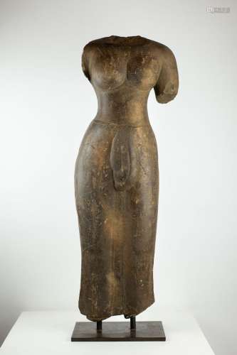 CAMBODIA，前吴哥艺术，8-9世纪。一个女性无头神的圆驼雕塑，可能是乌玛，代表站在很轻的tribangha。裸露的胸围显示出圆润大方的胸部。下半身则用刻有褶皱的细纱衣覆盖。在腰间打一个大结。深灰色硬砂岩。高度：74厘米。一些明显的震动和缺失。