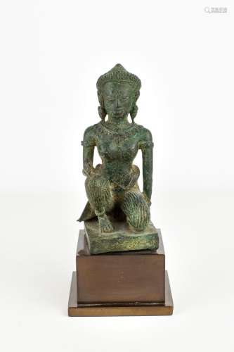 柬埔寨，高棉艺术十二世纪。女神(可能是乌玛女神)半跪姿态的圆凸雕。她戴着头饰和首饰，脸上带着很轻微的笑容。青铜色的绿色锈迹。 高。标题：11厘米原比利时收藏。